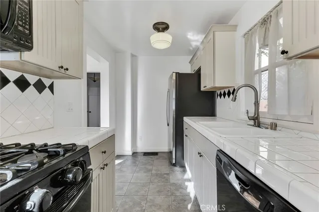 a kitchen with granite countertop a sink stove and refrigerator