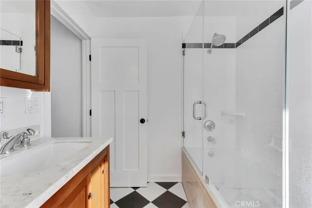 a bathroom with a granite countertop sink mirror and shower