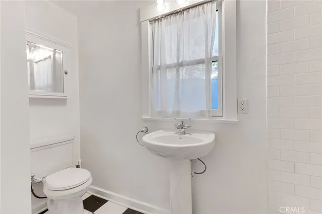 a bathroom with a sink toilet and mirror
