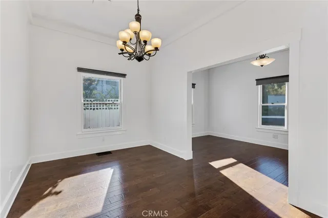 a view of a room with wooden floor and chandelier