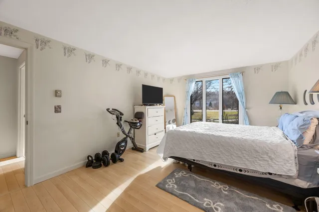 a bedroom with a bed and a flat tv screen on the dresser