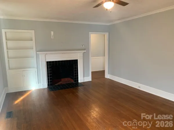 a view of a livingroom with a fireplace wooden floor and a window