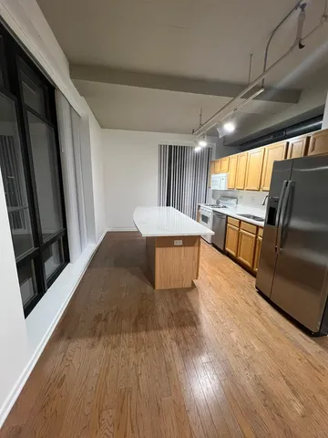 a large kitchen with a stove a refrigerator a sink and a large window