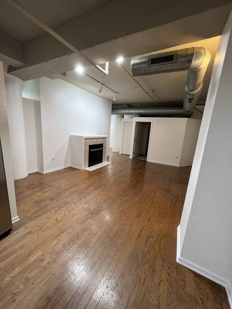 1525 South Sangamon Street, Unit 317P Chicago, IL 60608 - Photo 10 of 27 a view of an empty room and wooden floor
