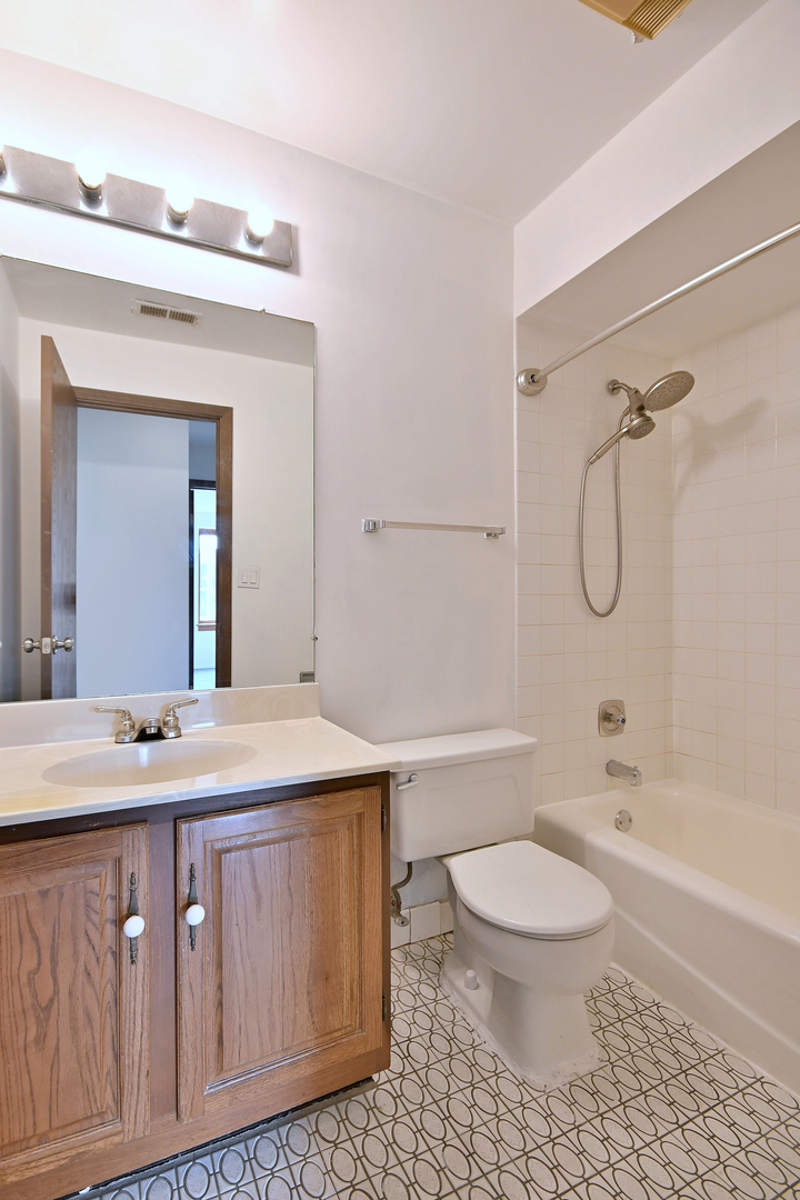 711 South River Road, Unit 508 Des Plaines, IL 60016 - Photo 24 of 41 a bathroom with a granite countertop sink a toilet mirror and bathtub