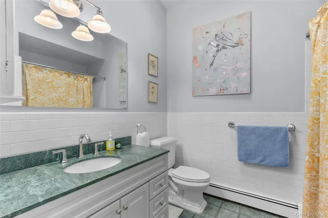 a bathroom with a granite countertop sink mirror and toilet