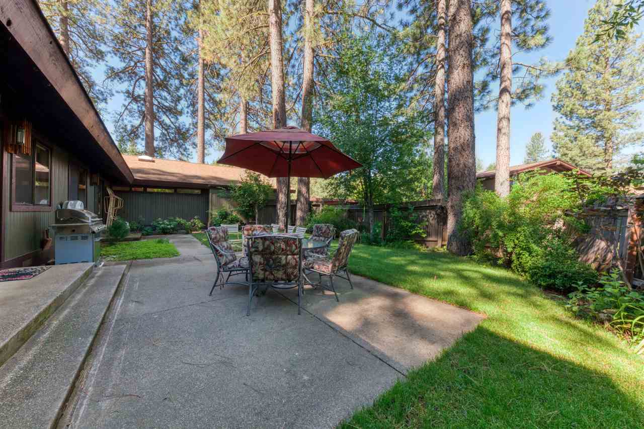 92 Graeagle Meadows Road Graeagle, CA 96103 - Photo 14 of 19 a view of patio with chairs and table under an umbrella with a barbeque