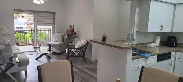 a living room with furniture a window and a potted plant