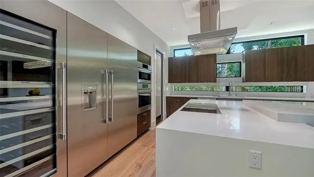 a kitchen with kitchen island a counter top space and stainless steel appliances