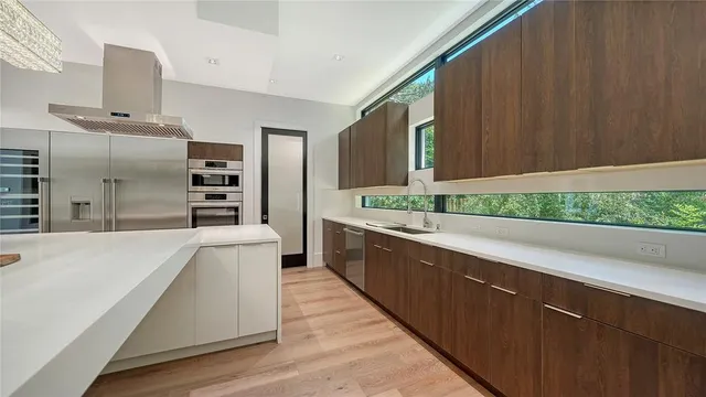 a large kitchen with kitchen island a sink stainless steel appliances and cabinets