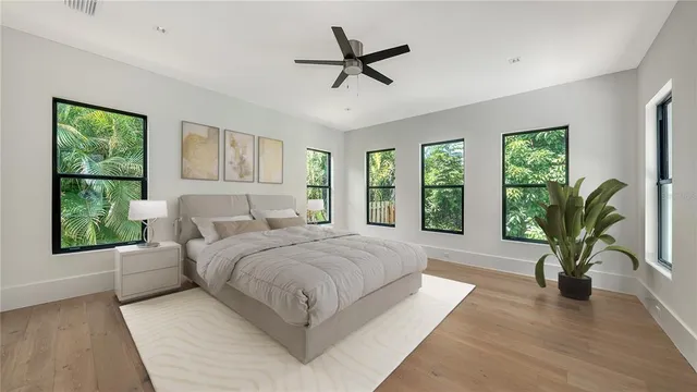 a spacious bedroom with a large bed and a potted plant
