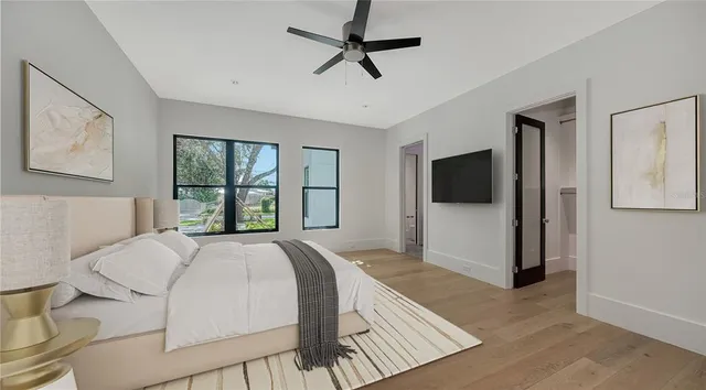 a spacious bedroom with a bed and a flat screen tv