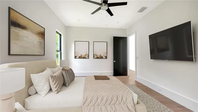 a bedroom with a large bed and a flat screen tv