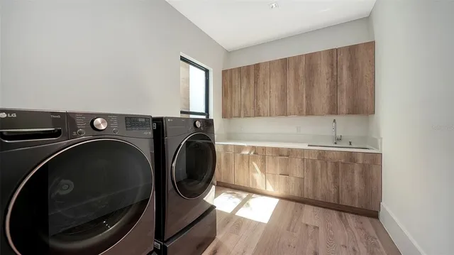 a utility room with sink dryer and washer