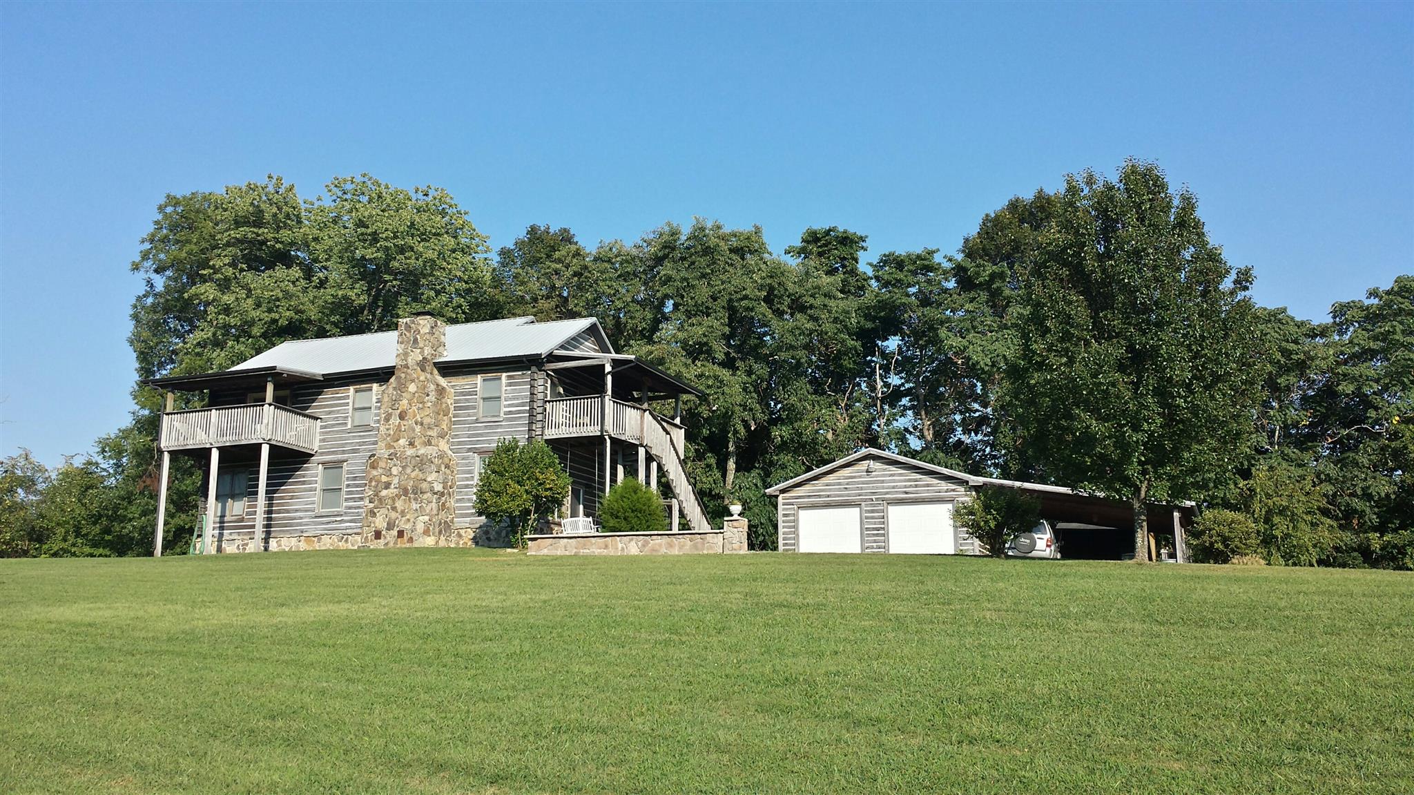 555 Windy Ridge Wartrace, TN 37183 - Photo 2 of 23 Side view of property showing two level stone fireplace and master bedroom private deck.