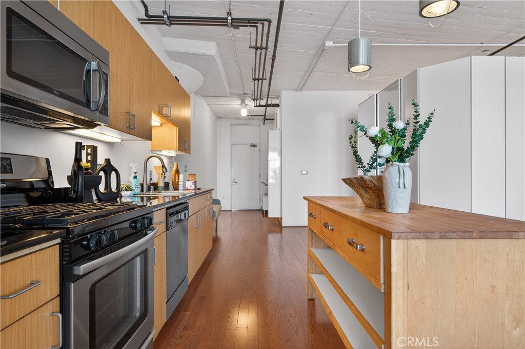 200 North San Fernando Road, Unit 315 Los Angeles, CA 90031 - Photo 9 of 42 a kitchen with stainless steel appliances granite countertop a sink a stove and a wooden floors