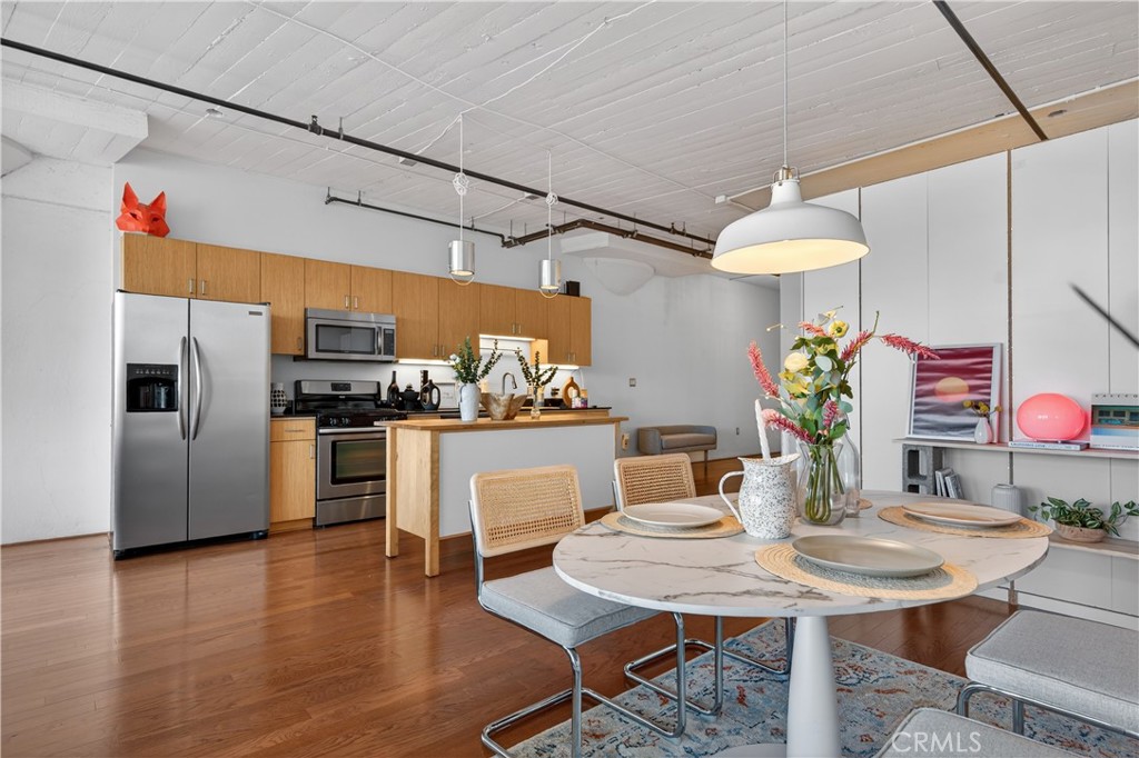 200 North San Fernando Road, Unit 315 Los Angeles, CA 90031 - Photo 10 of 42 a kitchen with stainless steel appliances kitchen island granite countertop a table chairs and a refrigerator