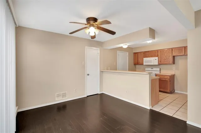 a view of a kitchen with a sink and dishwasher a refrigerator with wooden floor