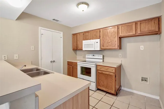 a kitchen with a stove sink and cabinets
