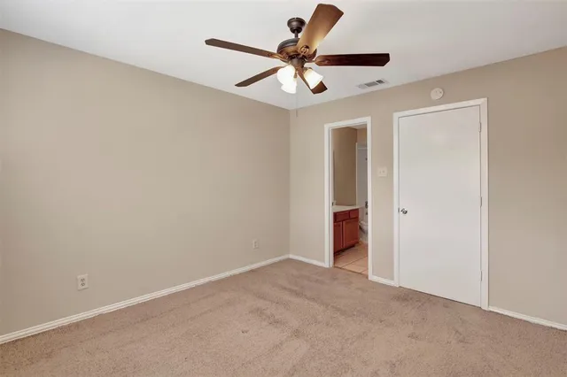 a view of an empty room with a ceiling fan