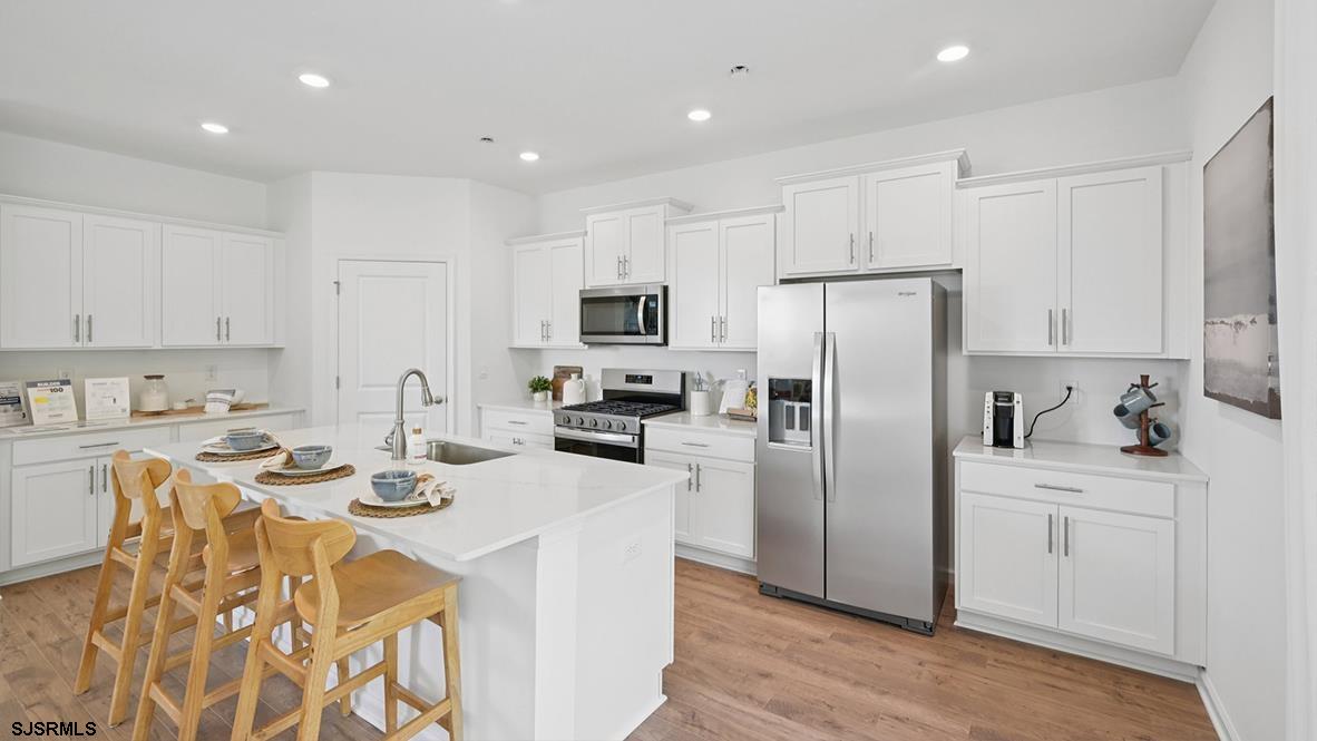 607 Scotty Boulevard, Unit 1404 Rio Grande, NJ 08242 - Photo 18 of 46 a kitchen with stainless steel appliances granite countertop a refrigerator a sink dishwasher a stove and white cabinets with wooden floor