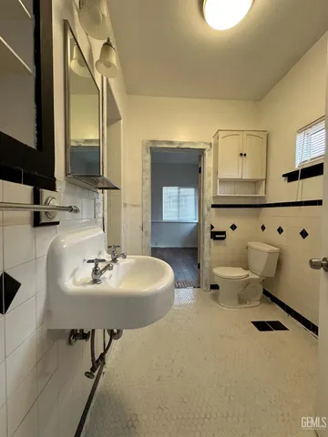 a bathroom with a toilet sink and mirror
