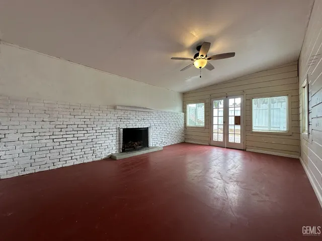 a view of empty room with fireplace and fan