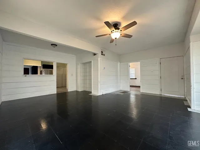 a view of a livingroom with wooden floor and a ceiling fan