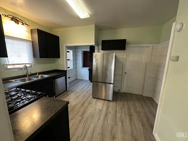 a kitchen with a refrigerator and a stove top oven