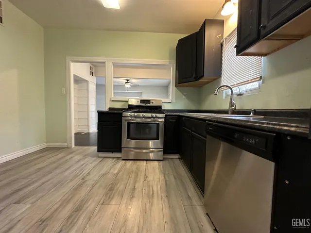 a kitchen with stainless steel appliances granite countertop a stove a sink and a microwave