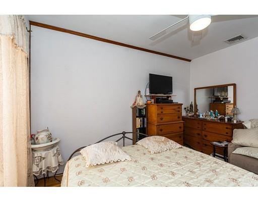36 Howard Road Medford, MA 02155 - Photo 14 of 39 a bedroom with a bed and a flat tv screen on a dresser