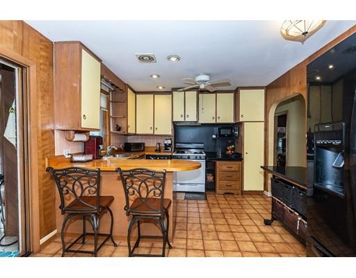 36 Howard Road Medford, MA 02155 - Photo 9 of 39 a kitchen with stainless steel appliances granite countertop a sink a stove a refrigerator cabinets and a dining table