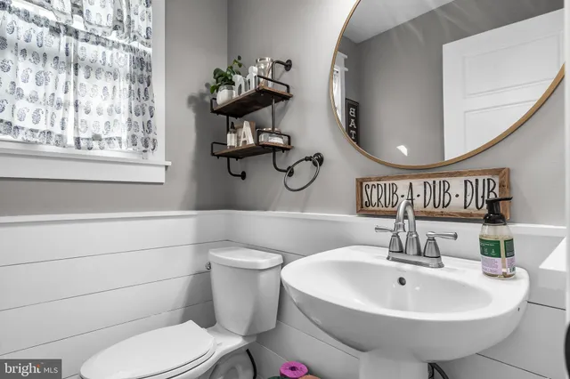 a bathroom with a sink a toilet and a mirror