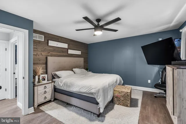 a bedroom with a bed and a flat tv screen on the dresser