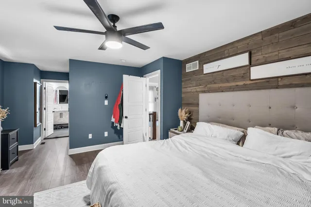 a bedroom with a large bed and a chandelier