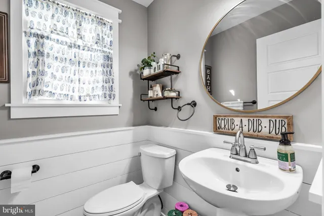 a bathroom with a sink a toilet and a mirror