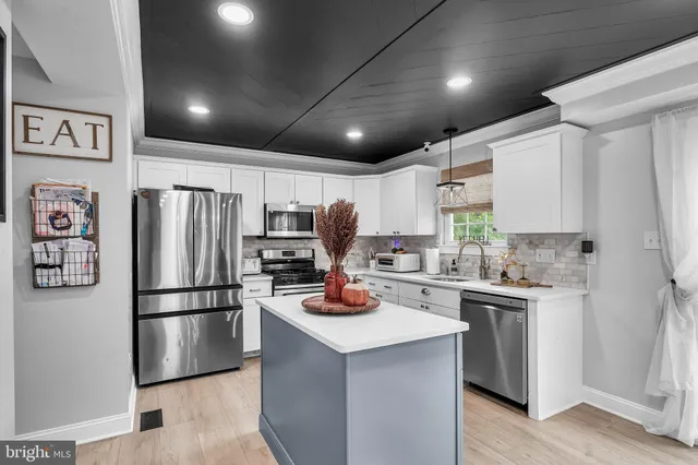 a kitchen with a refrigerator a stove a microwave and cabinets