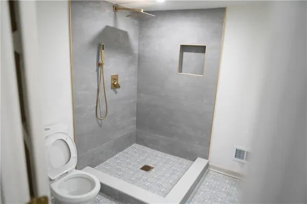 a bathroom with a sink a toilet and shower