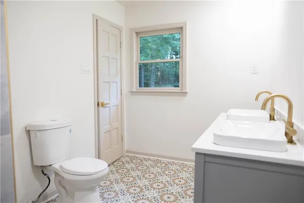 a bathroom with a sink toilet and a window