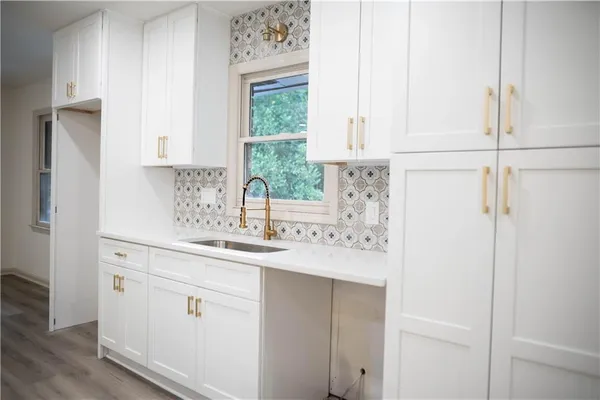 a kitchen with white cabinets and a sink