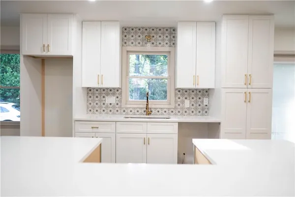 a kitchen with kitchen island granite countertop a sink window and cabinets
