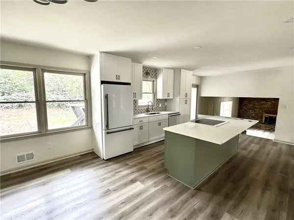 a kitchen with a stove a refrigerator and a fireplace