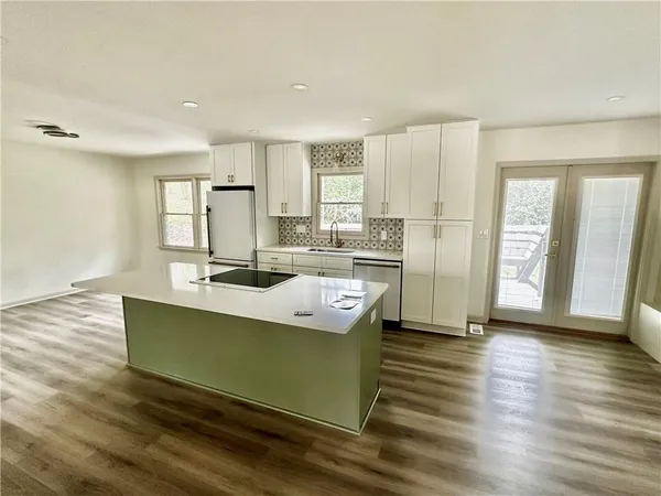 a kitchen with stainless steel appliances granite countertop a white cabinets and wooden floor