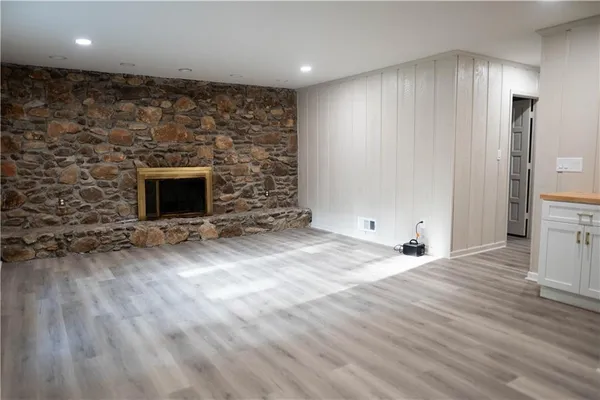 a view of empty room with wooden floor and fireplace
