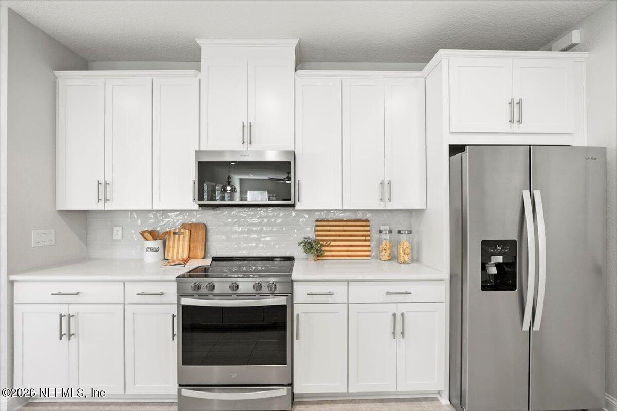 219 Morning Mist Lane St. Johns, FL 32259 - Photo 11 of 81 a kitchen with stainless steel appliances white cabinets and a stove