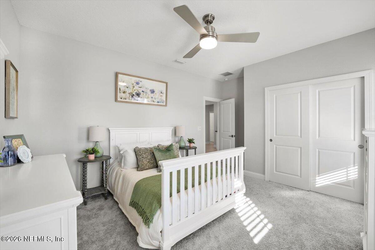 219 Morning Mist Lane St. Johns, FL 32259 - Photo 18 of 81 a bedroom with a bed and a chandelier