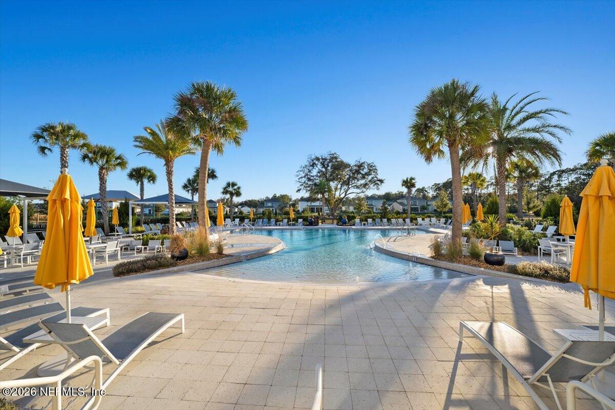 219 Morning Mist Lane St. Johns, FL 32259 - Photo 54 of 81 a view of a swimming pool with a lounge chair and palm trees