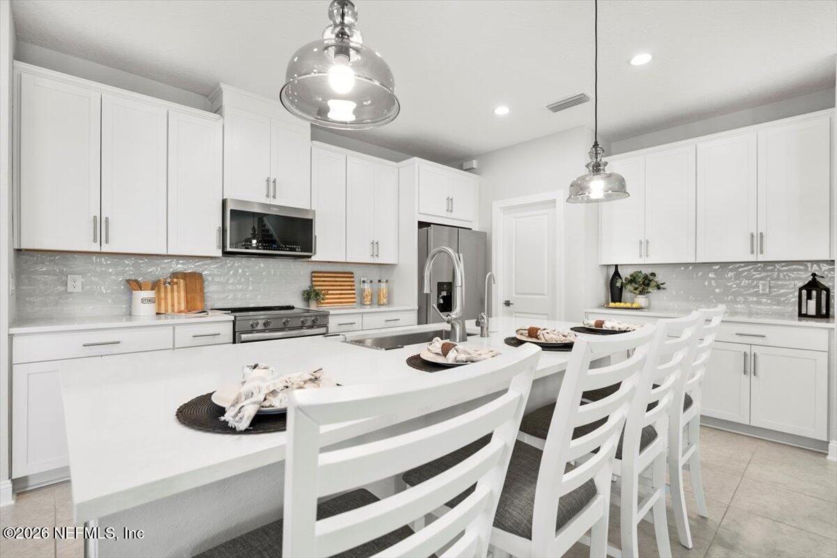 219 Morning Mist Lane St. Johns, FL 32259 - Photo 9 of 81 a kitchen with stainless steel appliances kitchen island granite countertop a sink and cabinets