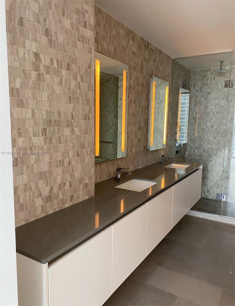 68 Southeast 6th Street, Unit 2904 Miami, FL 33131 - Photo 11 of 16 a large bathroom with a bathtub and a sink
