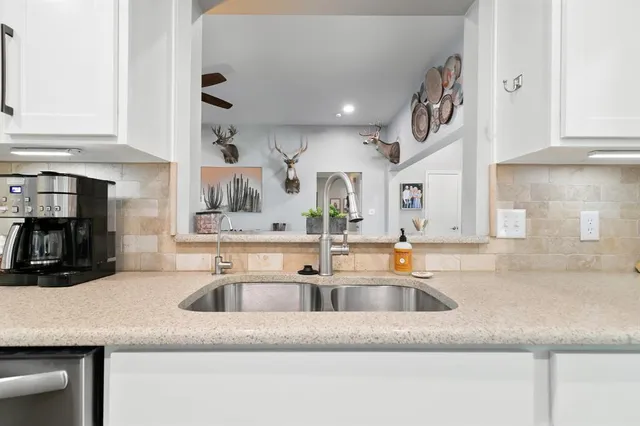 a kitchen with stainless steel appliances granite countertop a sink a microwave and cabinets